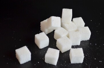 refined sugar cubes on black background