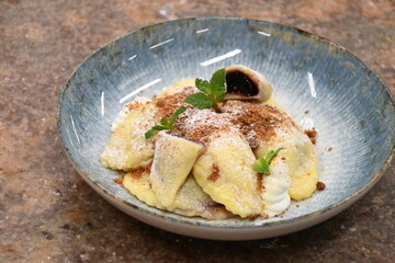 traditional european sweet dish varieniki pastries with blueberries, sweet lunch served food on a plate in a restaurant