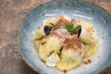 traditional european sweet dish varieniki pastries with blueberries, sweet lunch served food on a plate in a restaurant