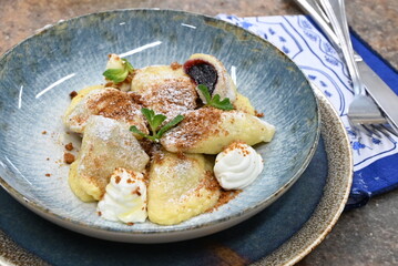 traditional european sweet dish varieniki pastries with blueberries, sweet lunch served food on a plate in a restaurant