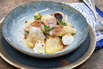 traditional european sweet dish varieniki pastries with blueberries, sweet lunch served food on a plate in a restaurant
