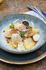 traditional european sweet dish varieniki pastries with blueberries, sweet lunch served food on a plate in a restaurant