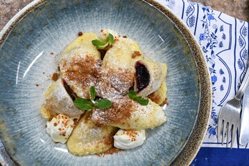 traditional european sweet dish varieniki pastries with blueberries, sweet lunch served food on a plate in a restaurant