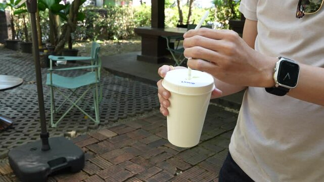 4k vdo close up of a person's hand holding a coffee cup and drinking it