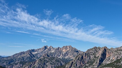 Majestic mountain range under a deep blue sky adorned with wispy clouds Perfect for adventurous and nature themed concepts