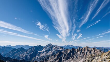 Majestic mountain range under a deep blue sky adorned with wispy clouds Perfect for adventurous and nature themed concepts