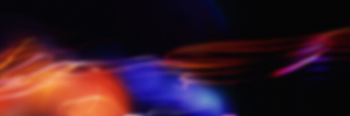 Blurred neon light streaks in red, orange, and blue on a dark background. Ideal for wallpapers and modern designs.