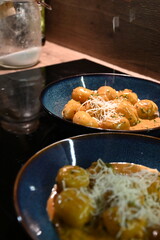 close up view of food background, potato gnocchi with pepper cream sauce, grated parmesan cheese and herbs, close up view of served food