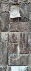 Wall of the building. Textured wall covered with stone tiles. The tiles are uneven and imitate real...