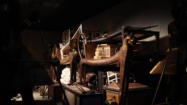 A collection of opulent artifacts from an ancient Egyptian tomb, including gilded furniture, chests, and ceremonial items. These treasures reflect the wealth and artistry of a bygone civilization.