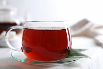 Refreshing black tea in cup on light table, closeup