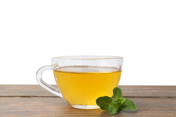 Aromatic mint tea in glass cup and fresh leaves on wooden table against white background
