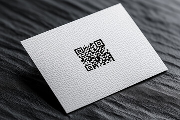 Blank white business card mockup with micro-embossed QR code design on textured surface