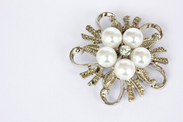 A silver flower-shaped brooch isolated on white background