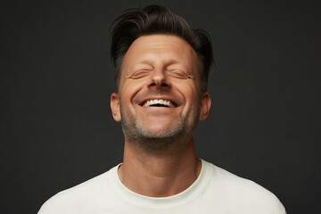 Fototapeta premium Studio portrait of man laughing with neutral gray background