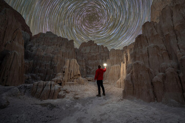 Night hiker exploring the entrance to a slot canyons known as Moon Caves in Cathedral Gorge State Park Nevada 