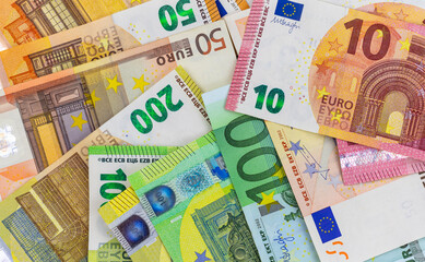 Euro banknotes, various denominations, scattered, top view.