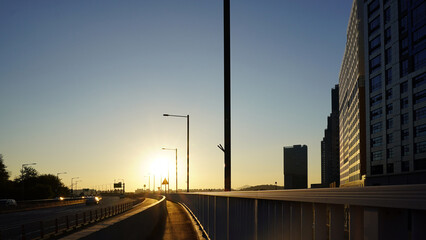 Urban Overpass and Highway at Sunset with Buildings, Sky, and Cars
