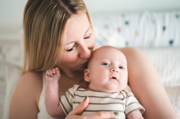 Cute small 1 month baby boy at home. Mother with little newborn infant.