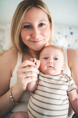 Cute small 1 month baby boy at home. Mother with little newborn infant.