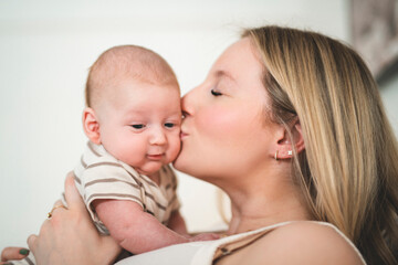 Cute small 1 month baby boy at home. Mother with little newborn infant.