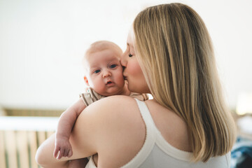 Cute small 1 month baby boy at home. Mother with little newborn infant.