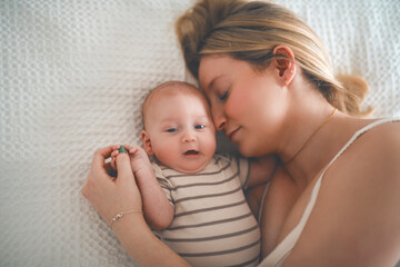 Cute small 1 month baby boy at home. Mother with little newborn infant.