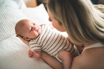Cute small 1 month baby boy at home. Mother with little newborn infant.
