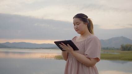 Naklejka premium Attractive Freelance Woman Relaxing and Working Remotely in Nature, work from anywhere , Learning Online. Digital nomad working remotely. social networks connected to 5g internet, Travel influencer