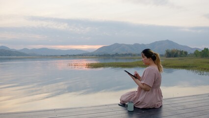 Asian Woman Using phone outdoors in the lake. Video Call, exploring, Virtual Meeting and Online Learning. Hybrid work lifestyle concept, artificial intelligence Talk with Ai, travel, influencer