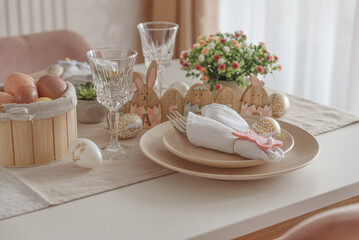Festive Easter table setting with Easter bunny made from napkin. Easter celebration concept