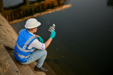 An environmental expert is collecting water samples to study the environment and the health of the...