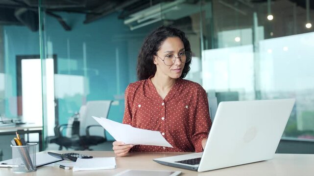 Happy young female financier finished work on financial report on laptop sitting at workplace in office. Smiling satisfied businesswoman puts her hands behind her head, leaning back in chair Work done