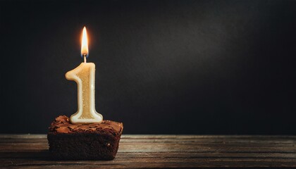 1st Anniversary candle lit on a cake with copy space