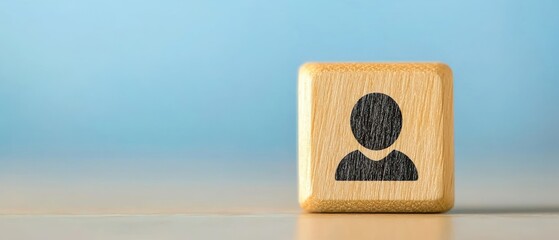 A close-up of a wooden block featuring a simple person icon, ideal for themes of identity, community, and connection.