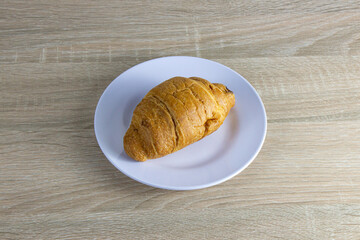 a plate of croissants on a wooden table