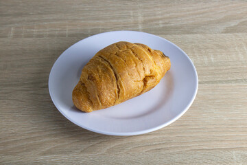 a plate of croissants on a wooden table