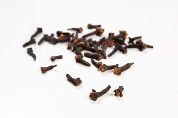Dried cloves lie on a white table