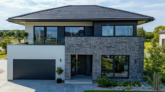 Modern two-story house with brick facade, captured from a high-angle view, showcasing sleek design. Ideal for real estate video content.