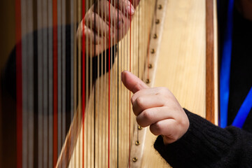Close-up of a woman's hands playing the harp