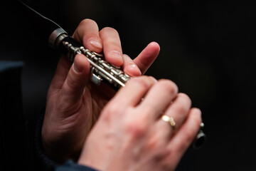 Close-up of musician's hands playing piccolo flute