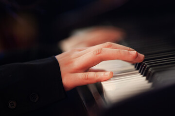 Fototapeta premium Girl's hand on piano keys close-up