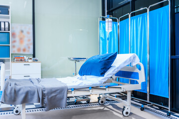 An empty medical bed sits in a glass hospital room, bathed in daylight. Equipped with adjustable features, it awaits the next patient, essential medical equipment for emergency and critical care.