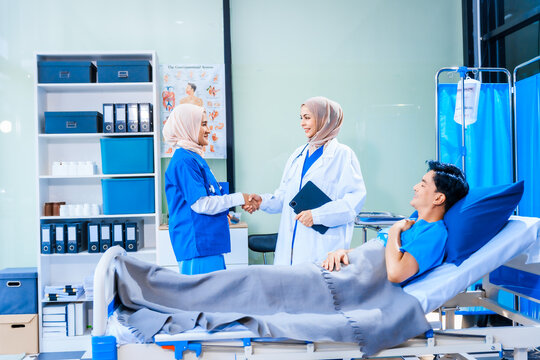 Asian middle-aged man patient rests in a hospital bed while a middle-aged Muslim woman doctor and a middle-aged Asian woman nurse check for diseases like flu and pneumonia, ensuring his recovery. - Powered by Adobe
