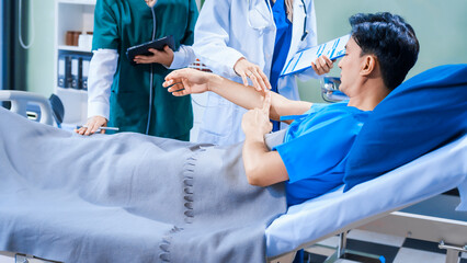 Asian middle-aged man patient rests in a hospital bed while a middle-aged Muslim woman doctor and a middle-aged Asian woman nurse check for diseases like flu and pneumonia, ensuring his recovery.