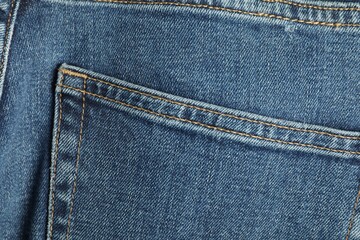 Stylish blue jeans with pocket as background, top view