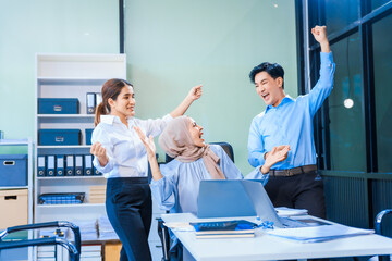 Obraz premium Middle-aged Asian man and Muslim woman in hijab sit across from each other in business meeting. They review report documents, discussing strategies and making decisions, successful, professional.