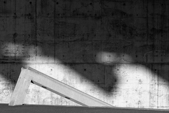 Shadow patterns cast on a concrete wall, emphasizing minimalist architecture and urban abstraction. The play of light and structure creates a striking geometric effect.