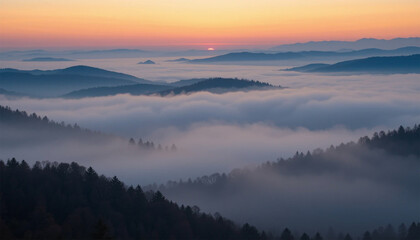 Fototapeta premium Mountain range covered in mist with sunrise light