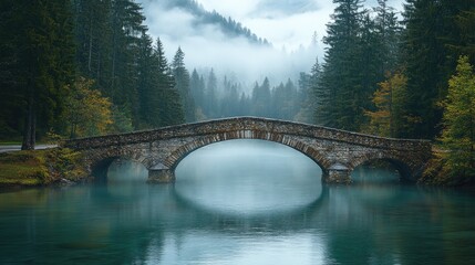 Fototapeta premium Stone Arch Bridge Over Misty Mountain Lake